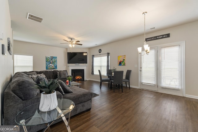 living room featuring ceiling fan with notable chandelier and dark hardwood / wood-style floors