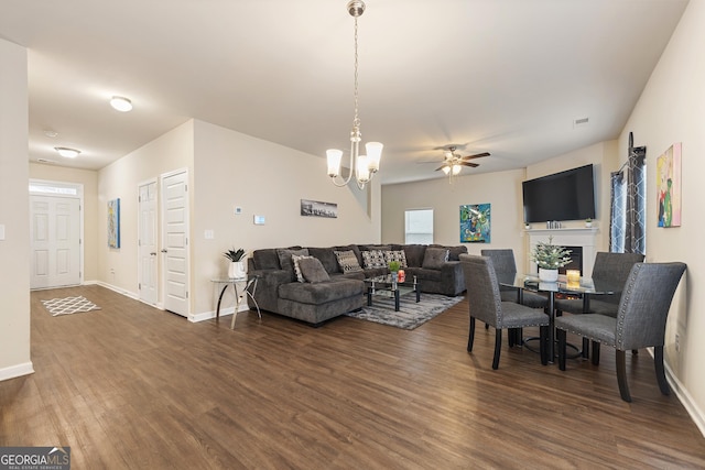 living room with dark wood-type flooring and ceiling fan with notable chandelier