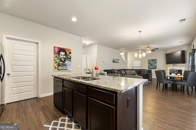 kitchen featuring black dishwasher, sink, a chandelier, dark brown cabinetry, and a center island with sink