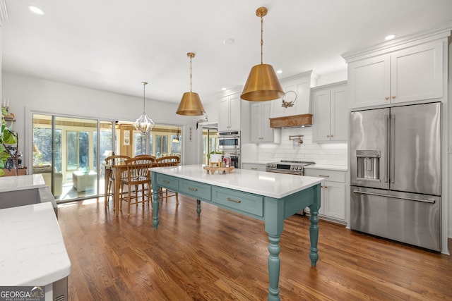 kitchen with pendant lighting, appliances with stainless steel finishes, backsplash, custom range hood, and white cabinets