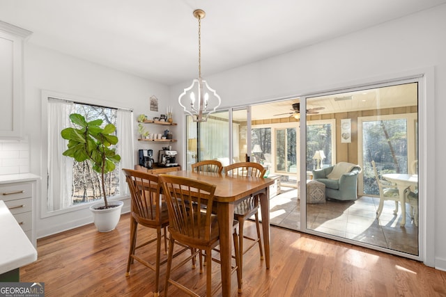 dining area with a wealth of natural light, a notable chandelier, and light hardwood / wood-style floors