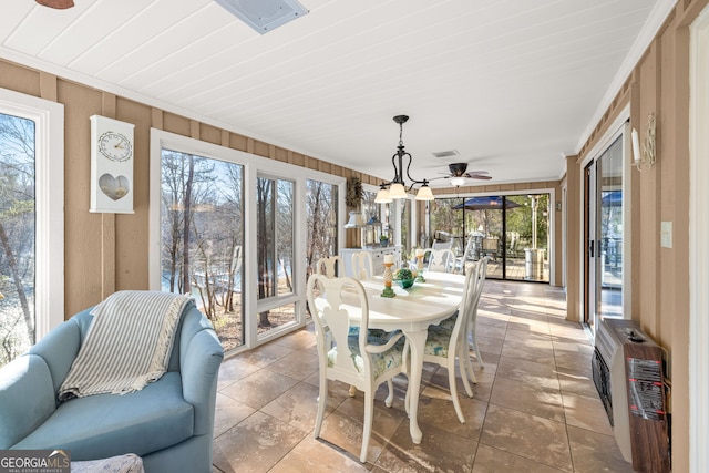 sunroom with heating unit and ceiling fan