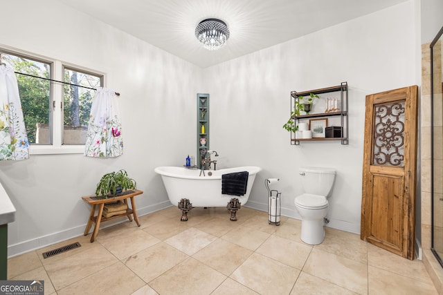 bathroom featuring tile patterned flooring, a tub to relax in, and toilet