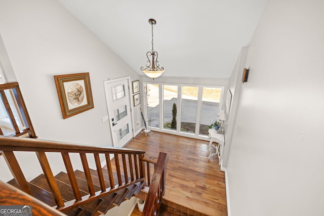 stairway featuring hardwood / wood-style flooring and lofted ceiling