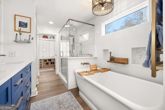 bathroom featuring vanity, hardwood / wood-style floors, and separate shower and tub