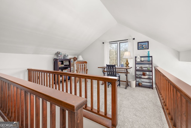 hall with lofted ceiling and light carpet