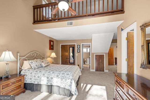 carpeted bedroom with a towering ceiling