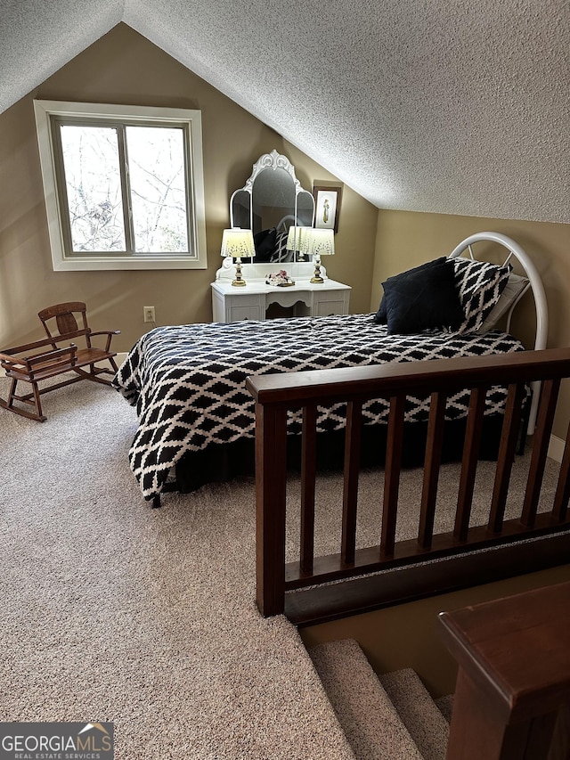 bedroom with vaulted ceiling, carpet flooring, and a textured ceiling