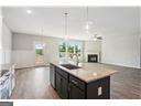 kitchen with pendant lighting, sink, light stone counters, and a center island