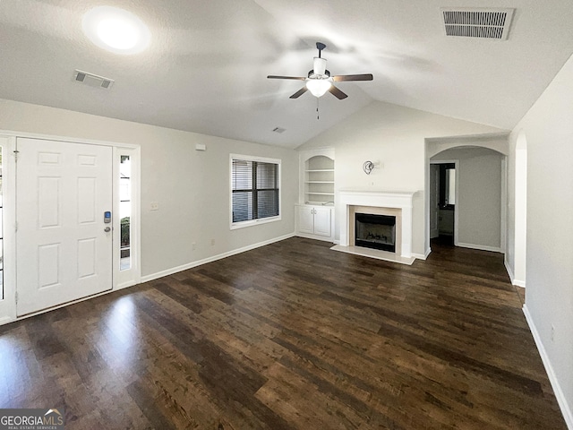 unfurnished living room featuring vaulted ceiling, a textured ceiling, dark hardwood / wood-style flooring, built in features, and ceiling fan