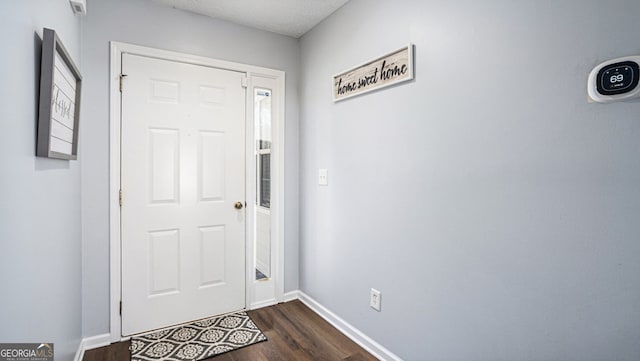 foyer with dark wood-type flooring and a textured ceiling