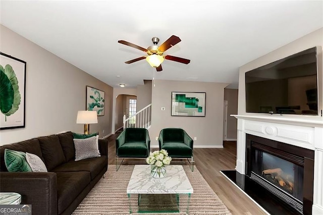 living room featuring light hardwood / wood-style flooring and ceiling fan