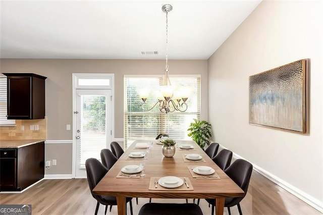 dining room with an inviting chandelier and light hardwood / wood-style flooring