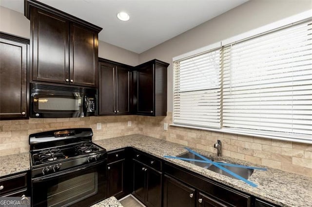 kitchen with sink, decorative backsplash, dark brown cabinetry, and black appliances