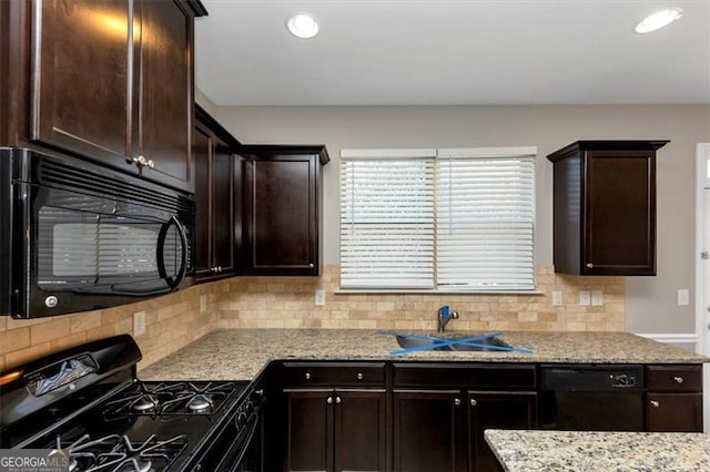 kitchen featuring sink, backsplash, light stone counters, black appliances, and dark brown cabinets