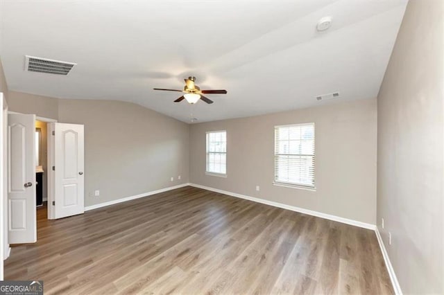 empty room featuring lofted ceiling, hardwood / wood-style floors, and ceiling fan