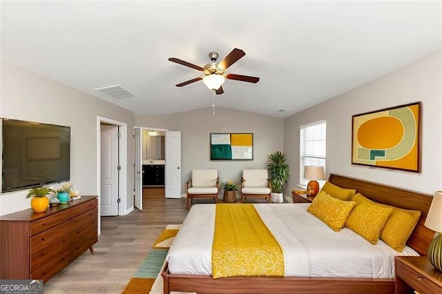 bedroom featuring vaulted ceiling, connected bathroom, ceiling fan, and light hardwood / wood-style floors