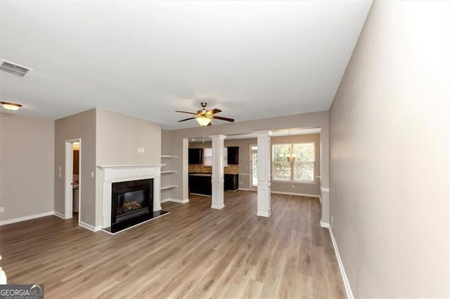 unfurnished living room with ceiling fan, light hardwood / wood-style flooring, and ornate columns