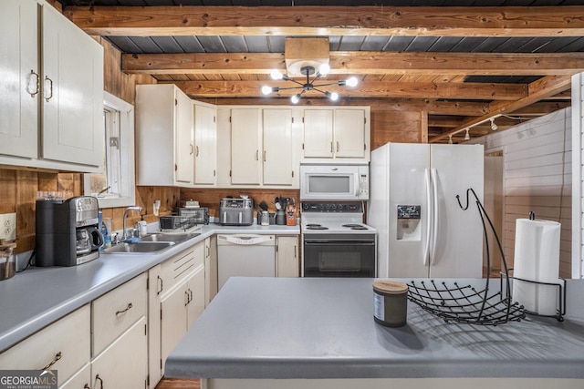 kitchen with sink, wooden walls, white appliances, beam ceiling, and white cabinets