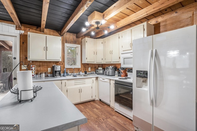 kitchen featuring wooden walls, beamed ceiling, white cabinetry, sink, and white appliances