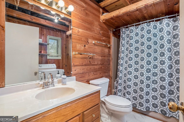 bathroom with vanity, washer / dryer, wooden walls, and toilet