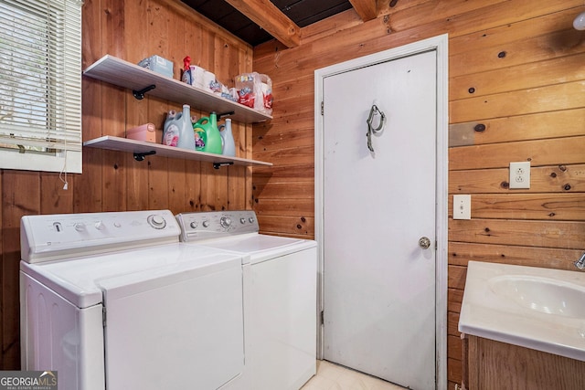 laundry area featuring sink, washer and clothes dryer, and wood walls