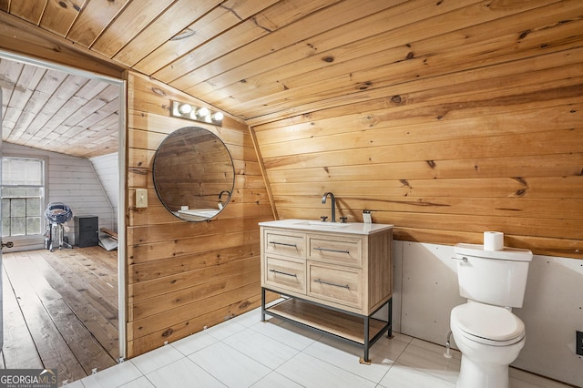 bathroom with wooden walls, lofted ceiling, vanity, toilet, and wooden ceiling