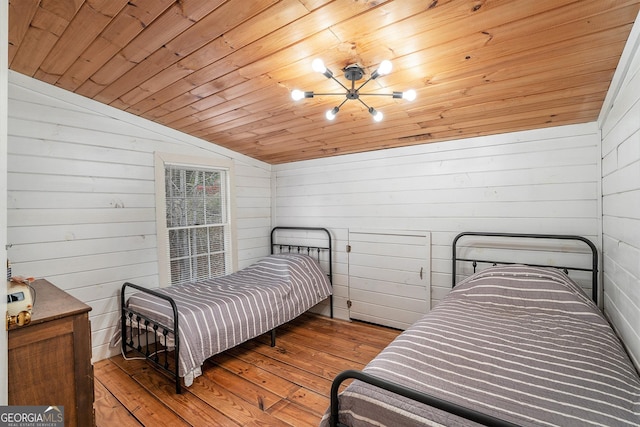 bedroom with lofted ceiling, wooden ceiling, wooden walls, and light wood-type flooring