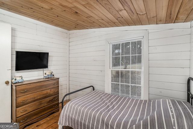 bedroom featuring wood ceiling and wood walls