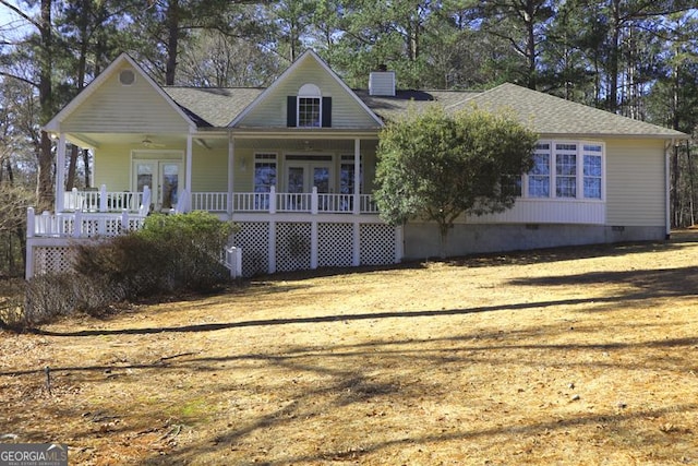 view of front of home featuring a front lawn, french doors, and covered porch