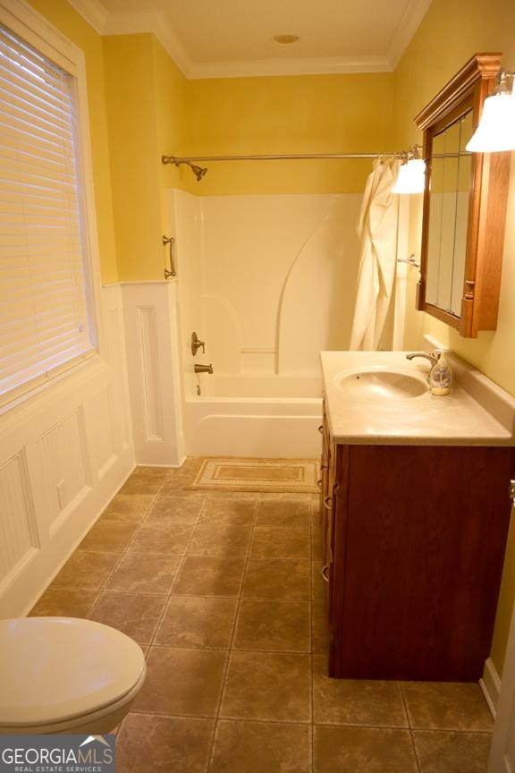 full bathroom with tile patterned flooring, vanity, toilet, crown molding, and tub / shower combination