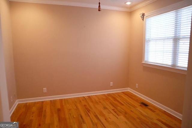 empty room with crown molding and hardwood / wood-style floors