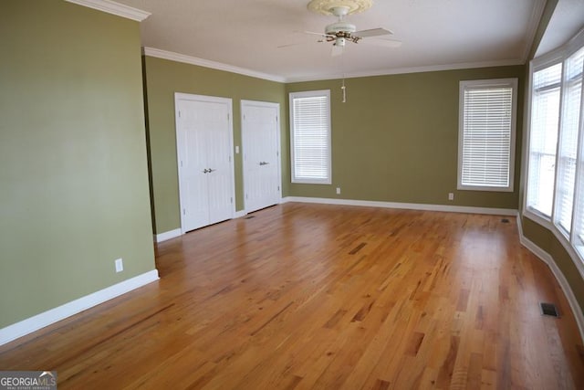 unfurnished bedroom featuring multiple windows, crown molding, and light hardwood / wood-style flooring