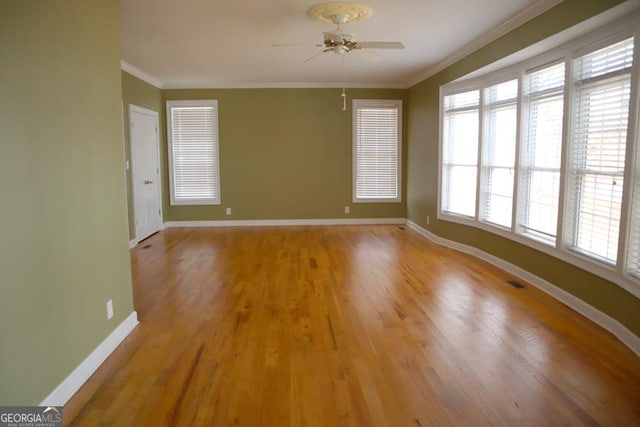 unfurnished room with hardwood / wood-style flooring, a healthy amount of sunlight, ornamental molding, and ceiling fan