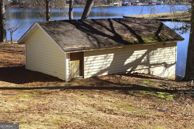 view of side of property featuring a water view and an outdoor structure