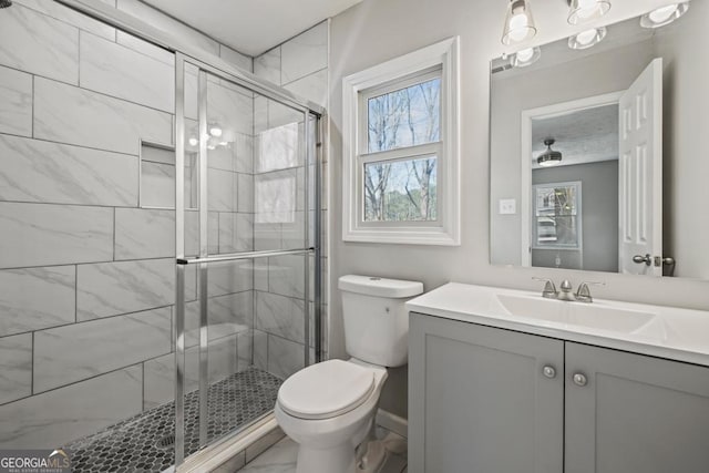 bathroom with walk in shower, vanity, and toilet