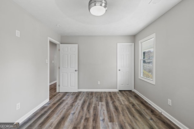 unfurnished bedroom with dark hardwood / wood-style flooring