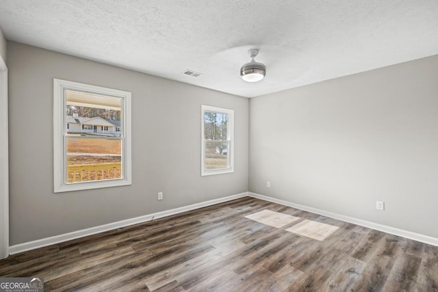 empty room featuring dark wood-type flooring and a textured ceiling