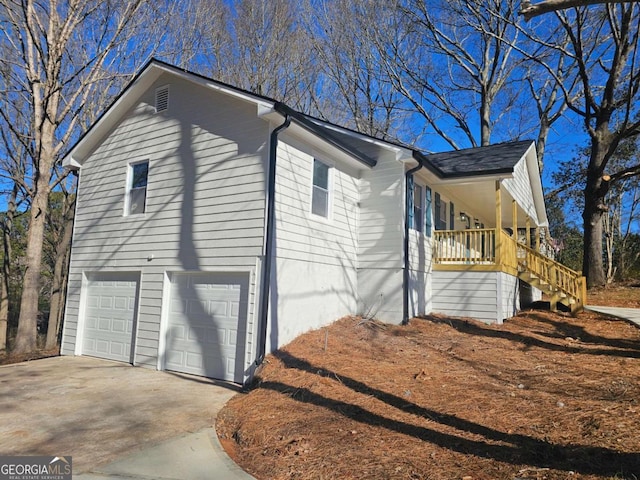 view of property exterior featuring a garage and a porch