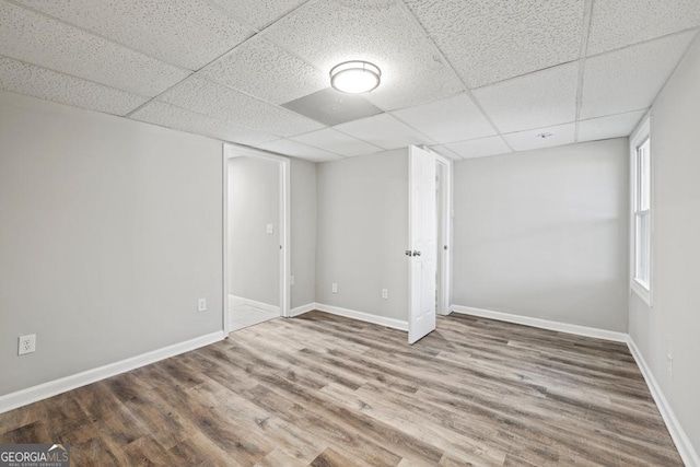 unfurnished room featuring wood-type flooring and a drop ceiling