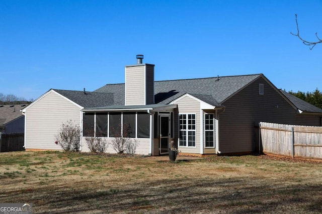 back of house with a lawn and a sunroom