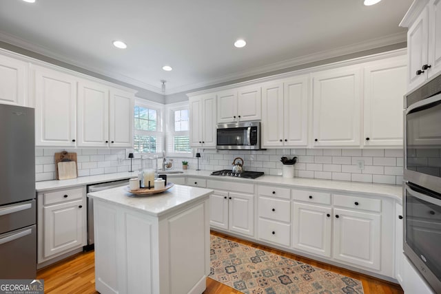 kitchen featuring a kitchen island, appliances with stainless steel finishes, white cabinets, and light hardwood / wood-style floors