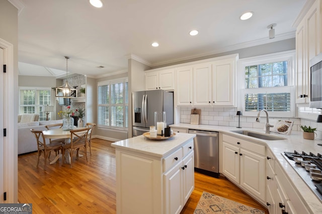 kitchen featuring white cabinetry, sink, a center island, and appliances with stainless steel finishes