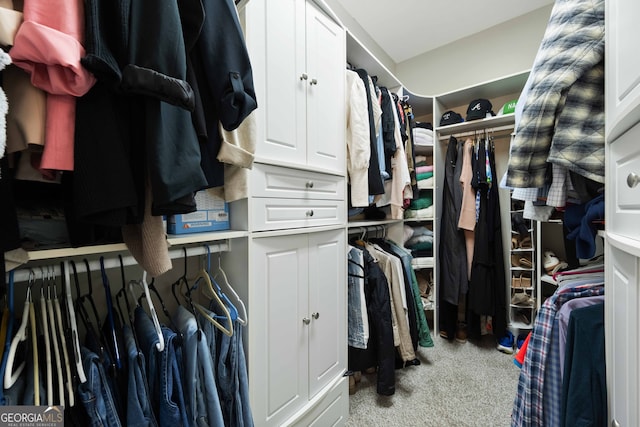 walk in closet featuring light carpet