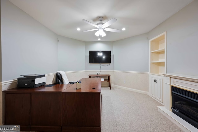 office area with light colored carpet, built in features, and ceiling fan