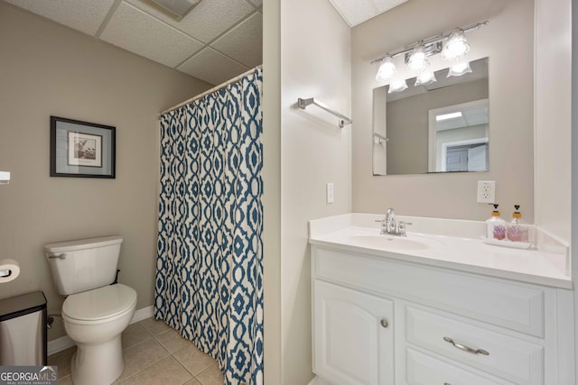 bathroom with vanity, a paneled ceiling, tile patterned floors, and toilet