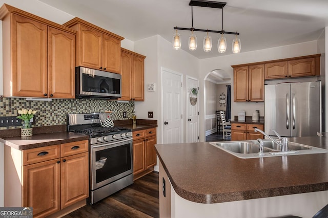 kitchen featuring sink, hanging light fixtures, an island with sink, and appliances with stainless steel finishes