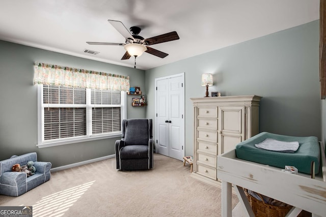 bedroom featuring light carpet, ceiling fan, and a closet