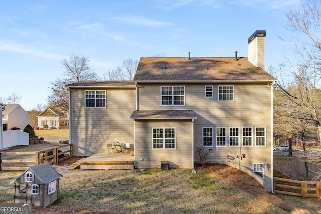 rear view of house featuring a wooden deck