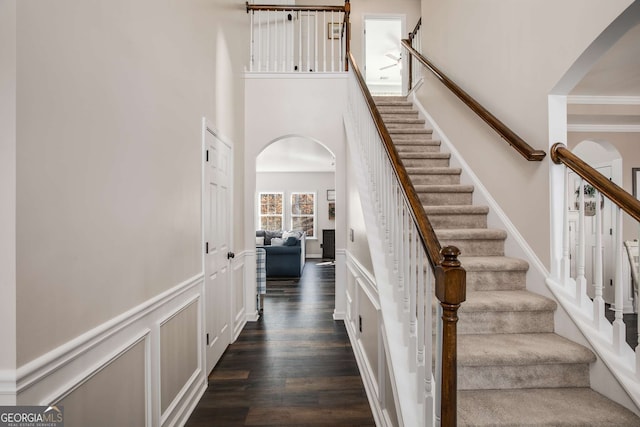 staircase with hardwood / wood-style floors and a high ceiling